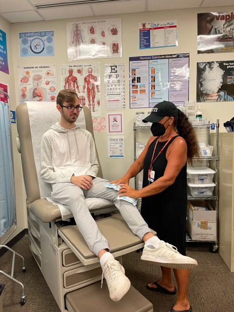 Student's knee being iced by nurse