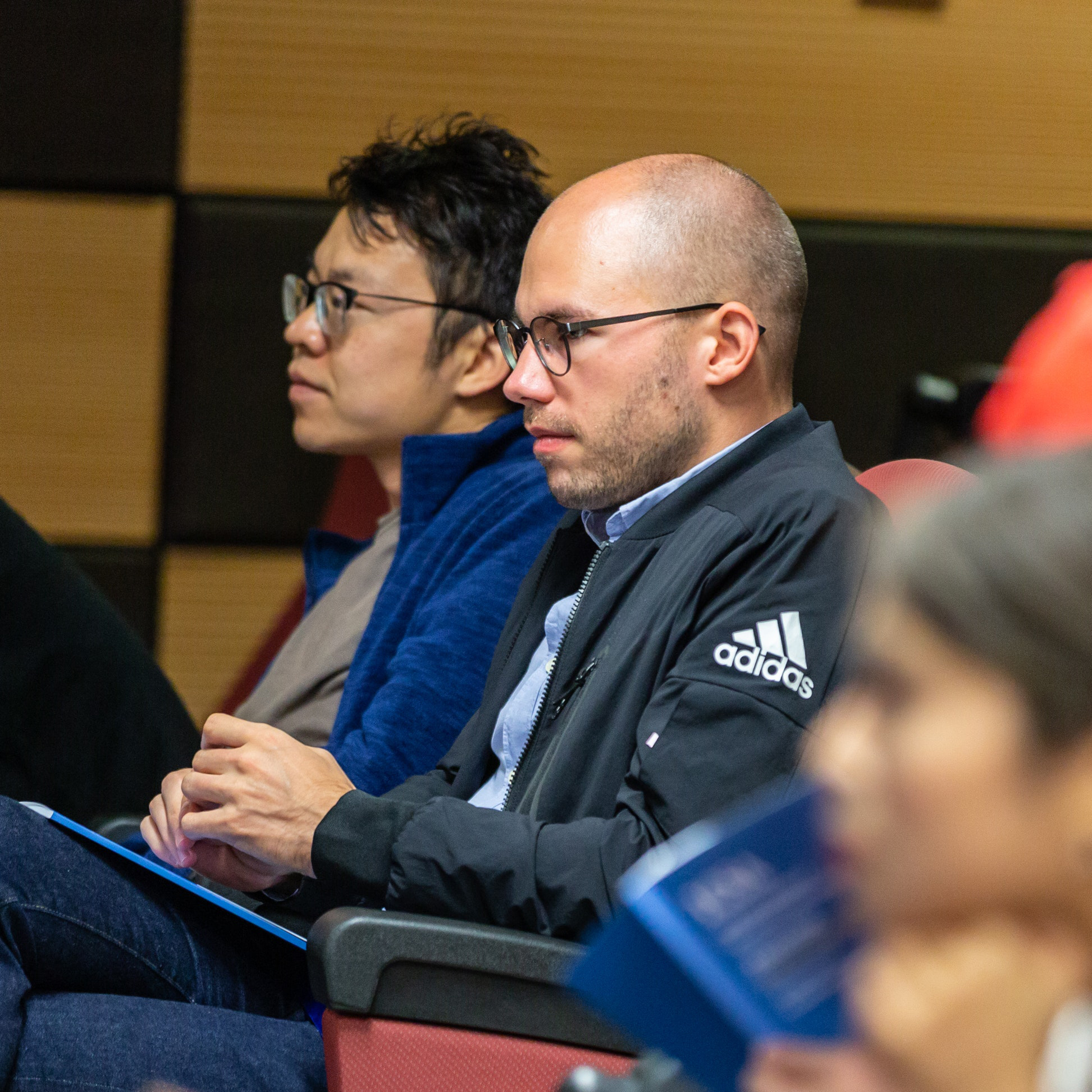 Some participants sitting at an event in a lecture hall.