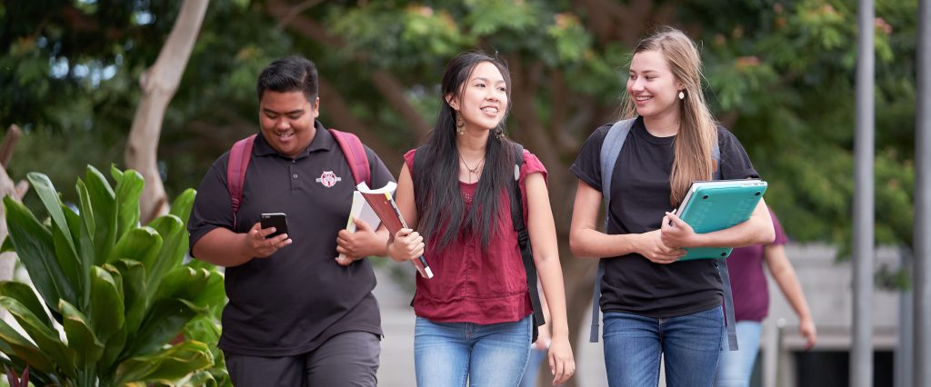 Three students walking in the courtyard.