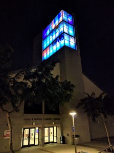 Nighttime photo of front of the library with tower lit up