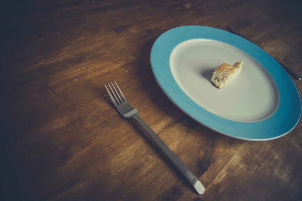 photo of a dinner plate with small piece of bread on it