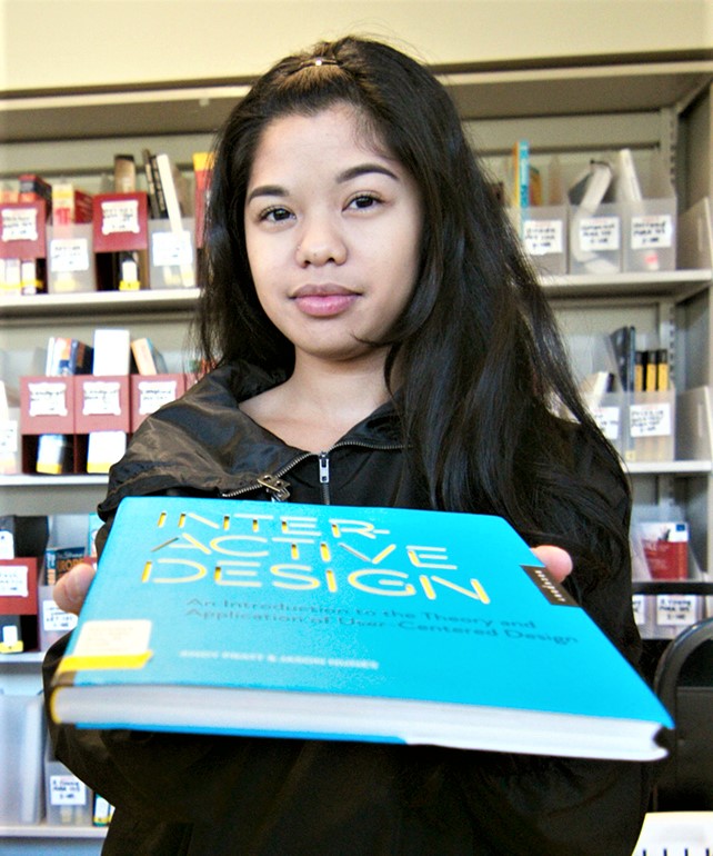 Photo of a student handling a book