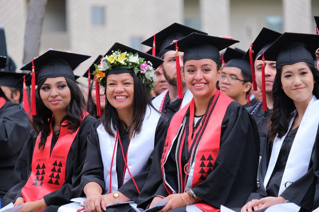 Graduates from the Fall 2019 class smiling at the commencement ceremony.
