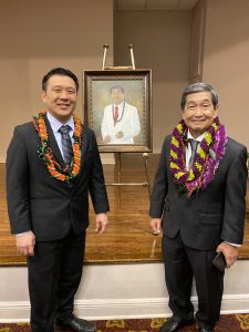 Chadwick Kamei, Michael Nakasone, and between them, an easel with a painting of Nakasone.