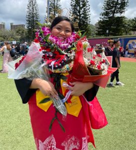 Smiling woman at graduation with flowers