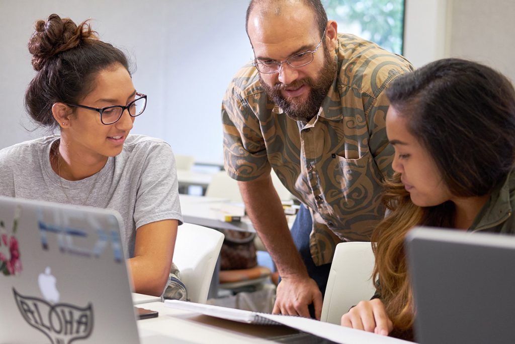 A faculty member helping his students in class.