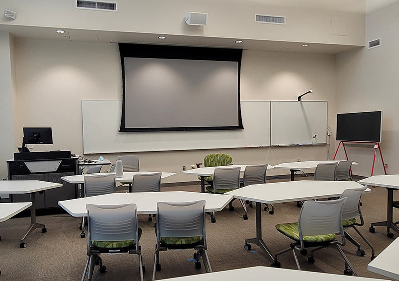 An classroom with the lights and AV equipment on.