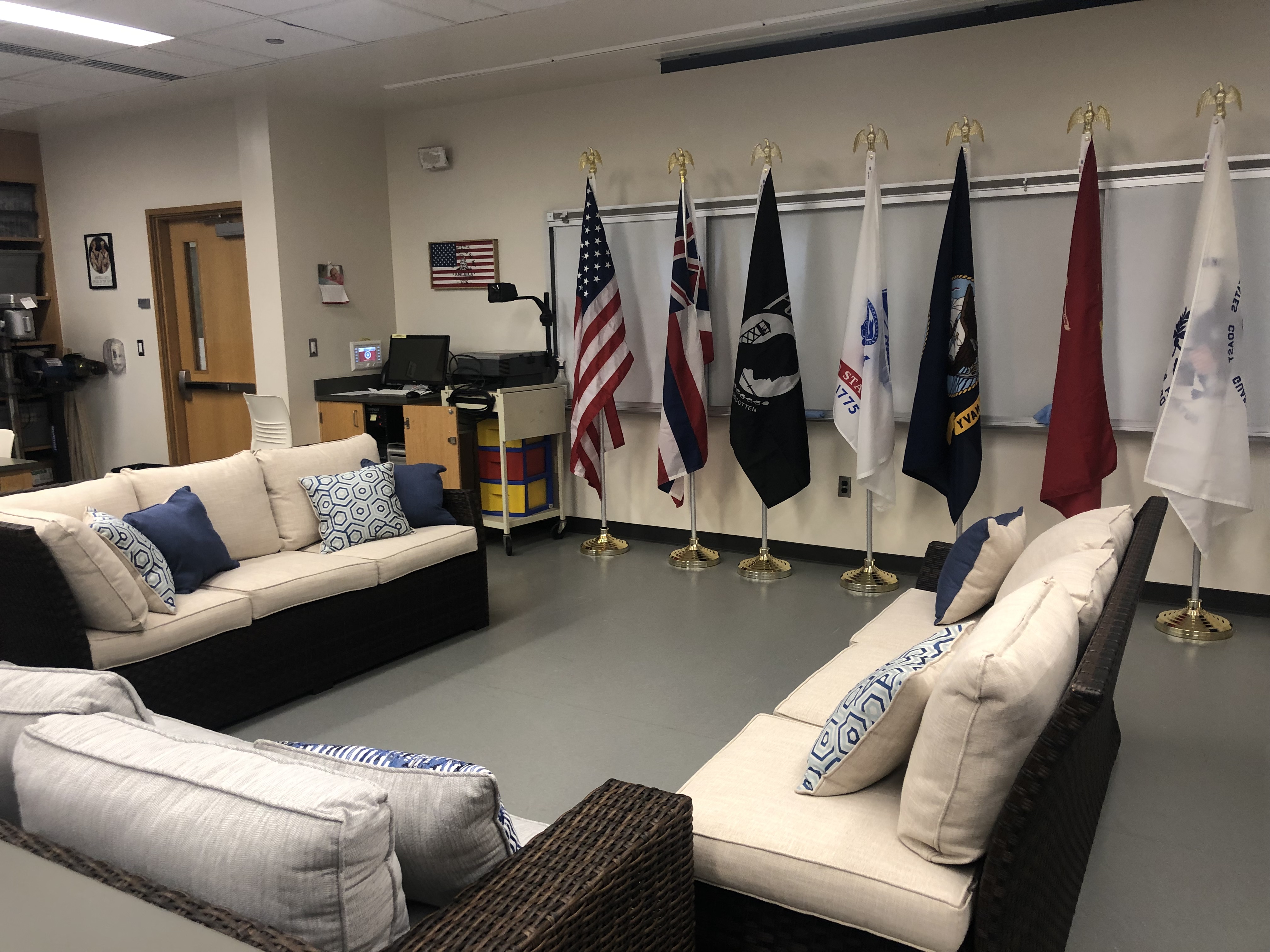 Pictures of couches where students can gather at the UH West O'ahu Veterans Lounge, decorated with flags representing the U.S. Armed Forces.