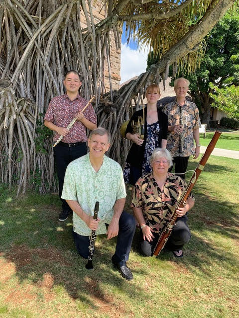 Members of Chamber Music Hawaiiʻs Spring Wind Quintet pose outdoors for a group photo while holding various instruments.