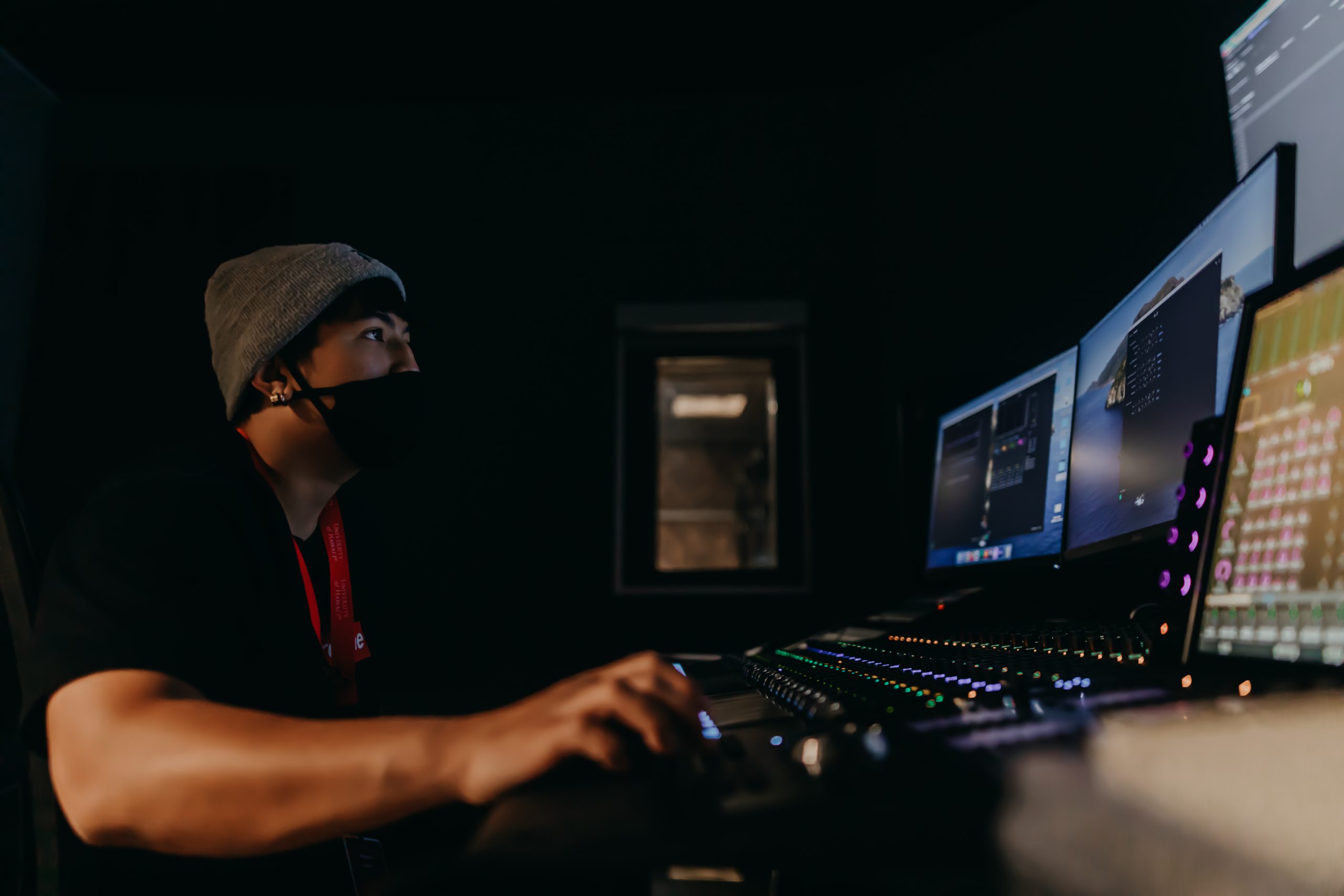 A student sitting at an editing bay and editing a video.