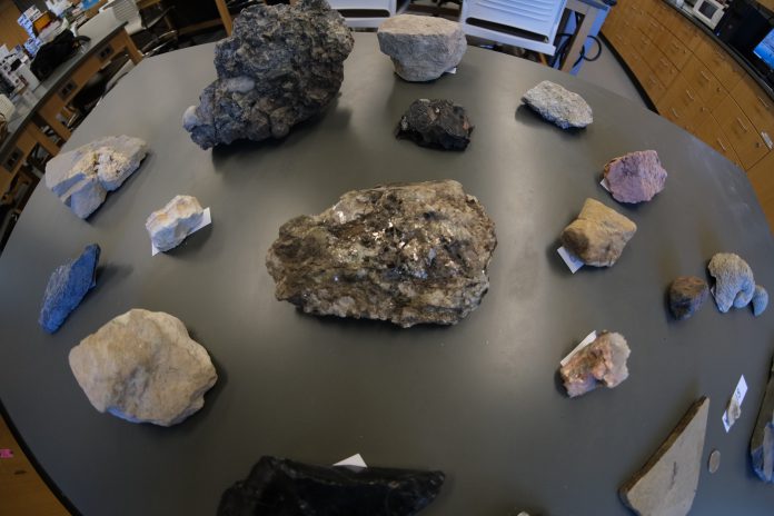 Various rocks, minerals, and fossils displayed on a table.