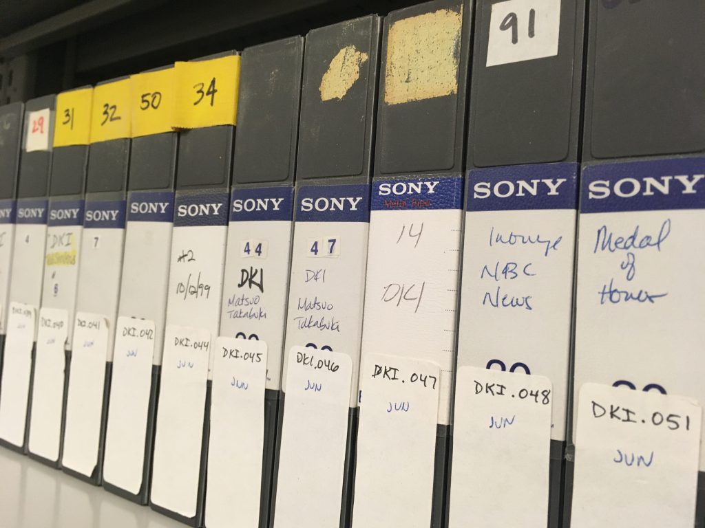 A shelf of labeled videotapes.