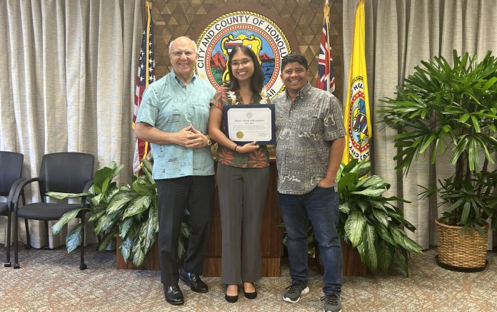 A woman holding a certificate and standing between two men.