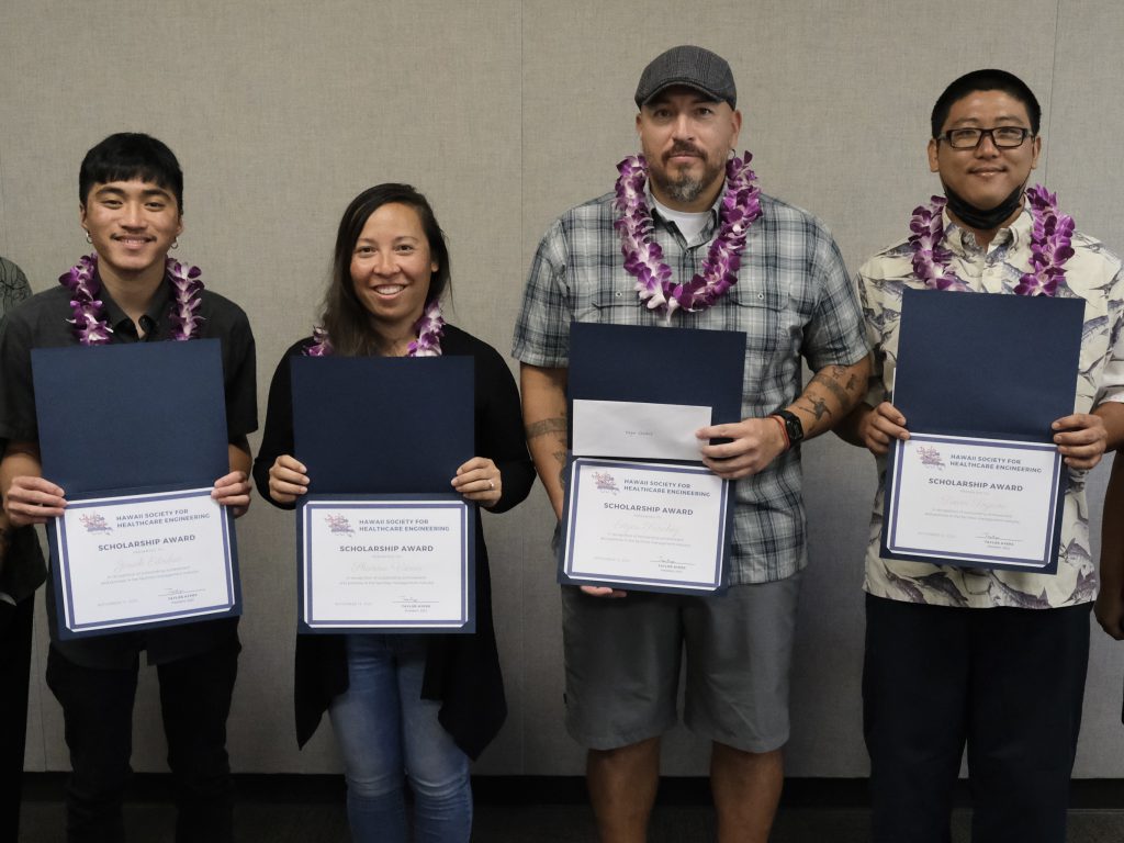 Four students wearing lei and holding certificates.