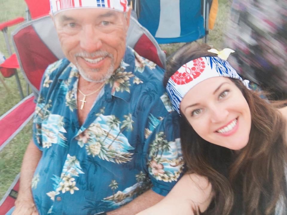 A father and his daughter wearing bandanas on their heads and smiling at the camera.