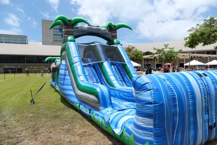 Giant wave-shaped inflatable slide on water.