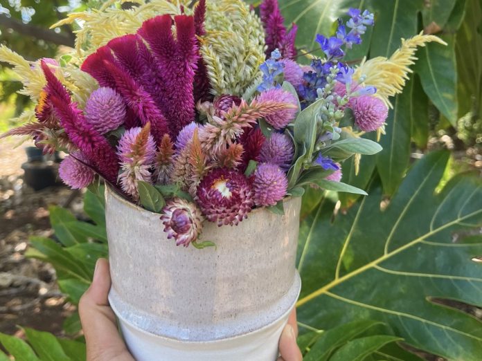 Outdoor image of an arrangement of flowers in a vase.