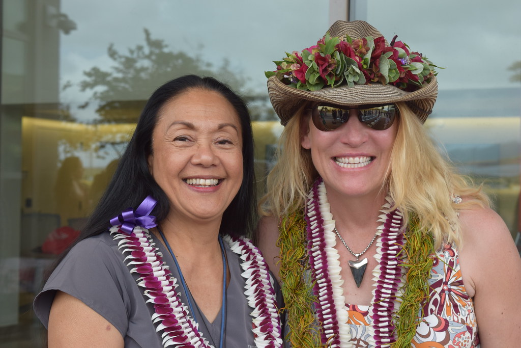 Two women smiling and wearing lei.