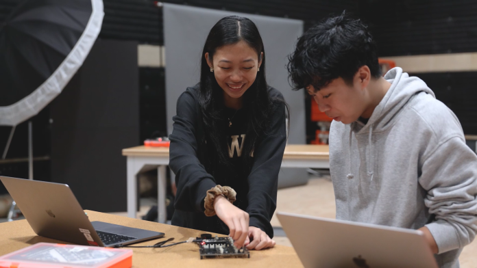 Two students working on a circuit board.