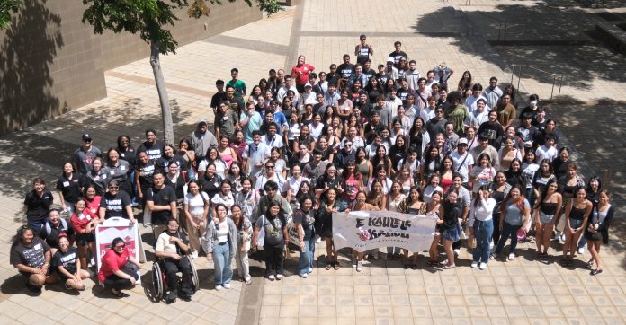 Almost 200 men and women posing for a group photo.