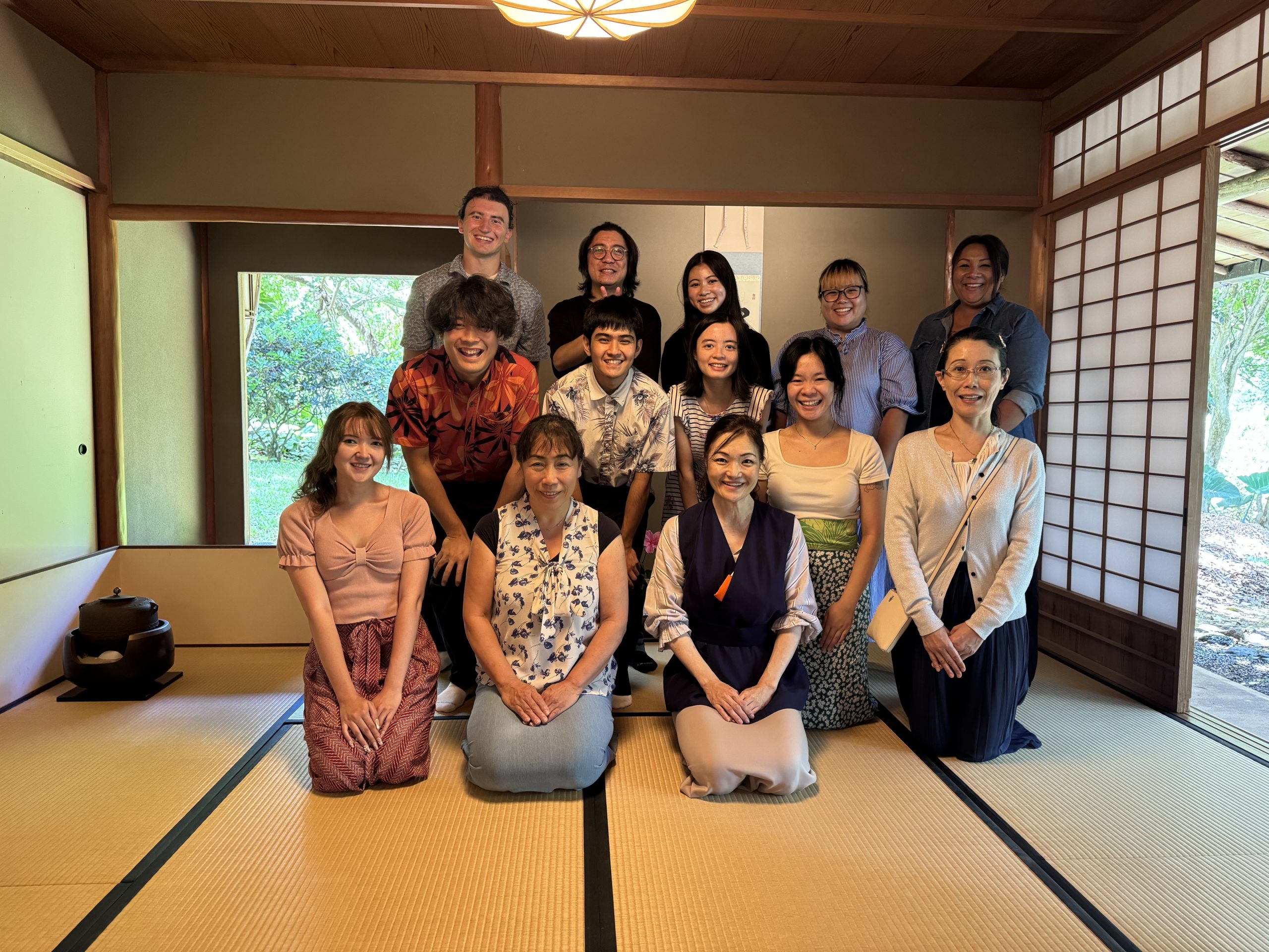 Men and women posing for a group photo in a tea house.
