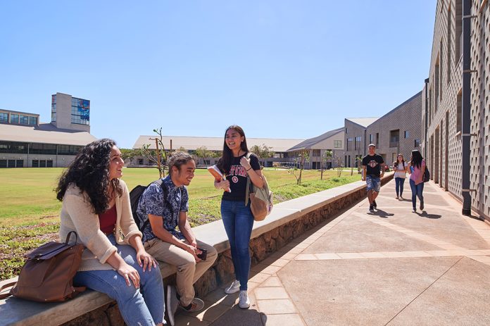 Students hanging out outdoors on a college campus.