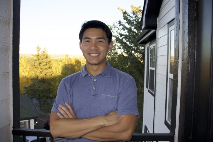 A man standing outdoors and smiling.