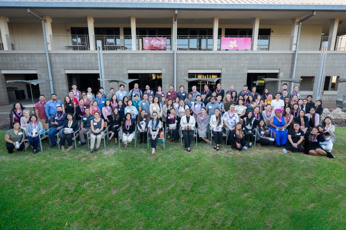 An outdoor group photo with more than 100 men and women.