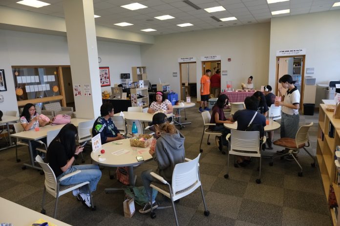 A group of students sitting at tables in a room.