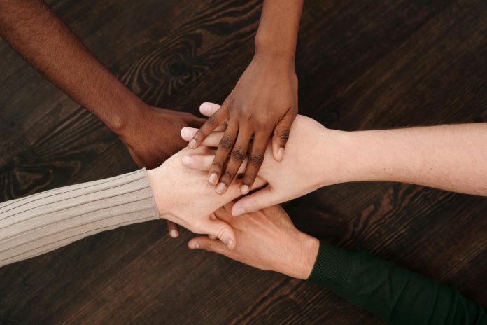 Five different hands on top of each other.