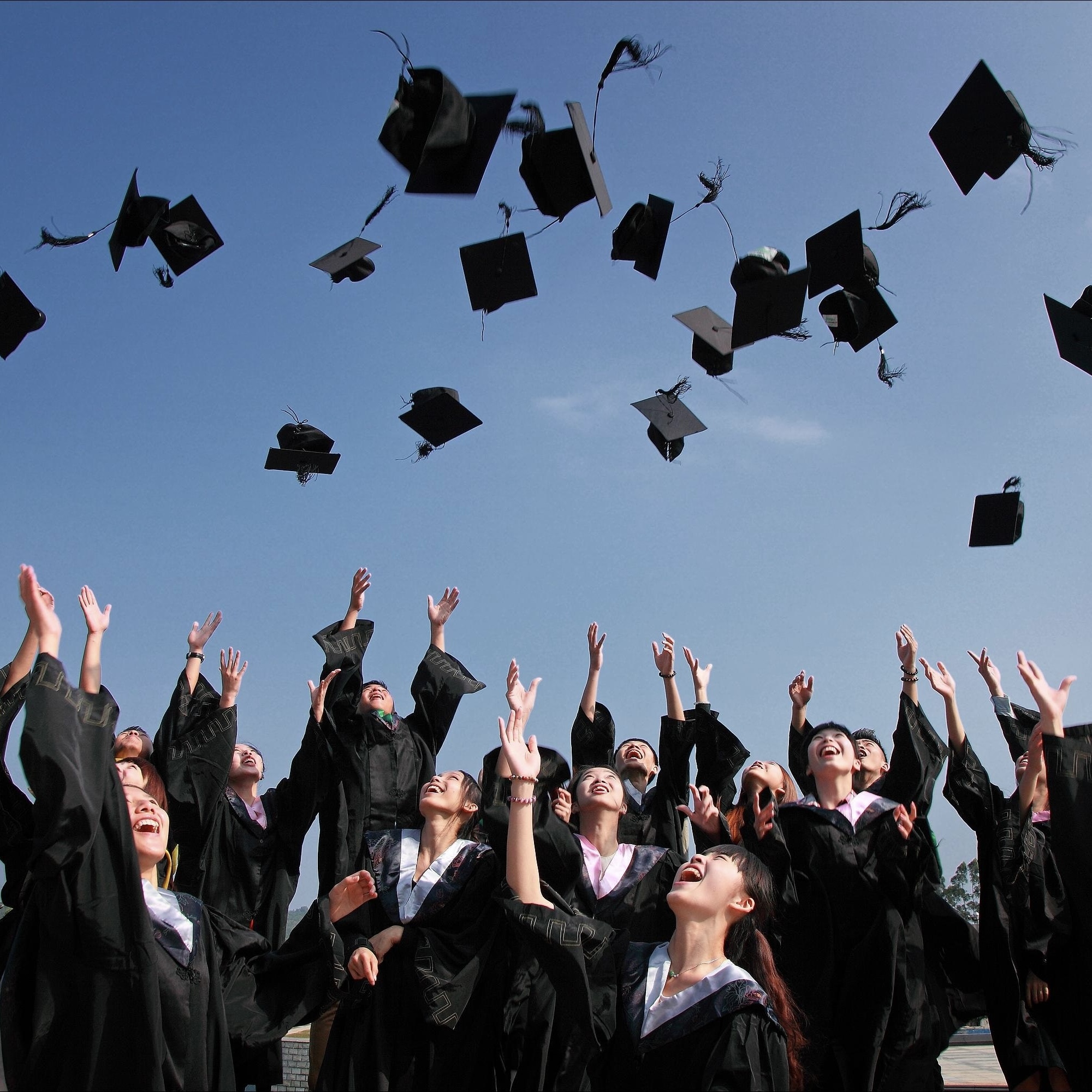 Graduates throwing their caps into the air.