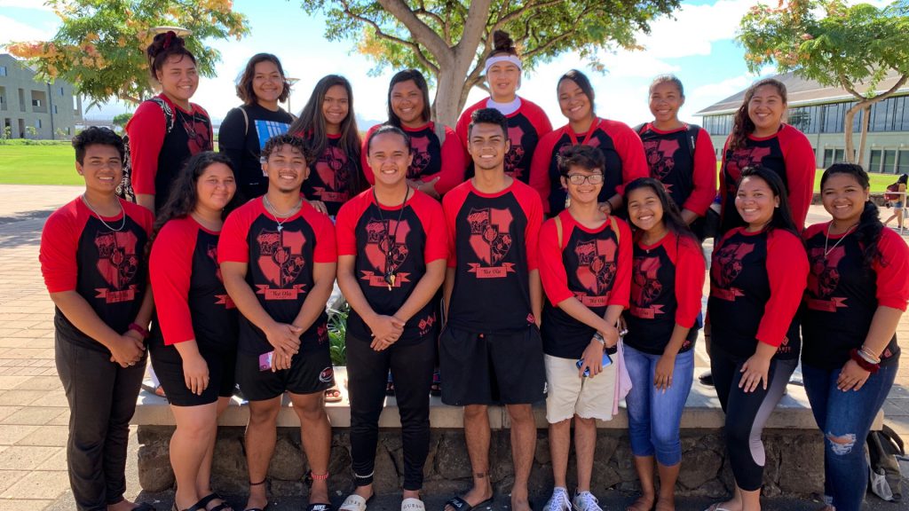 group of students gathered in front of a tree taking a picture
