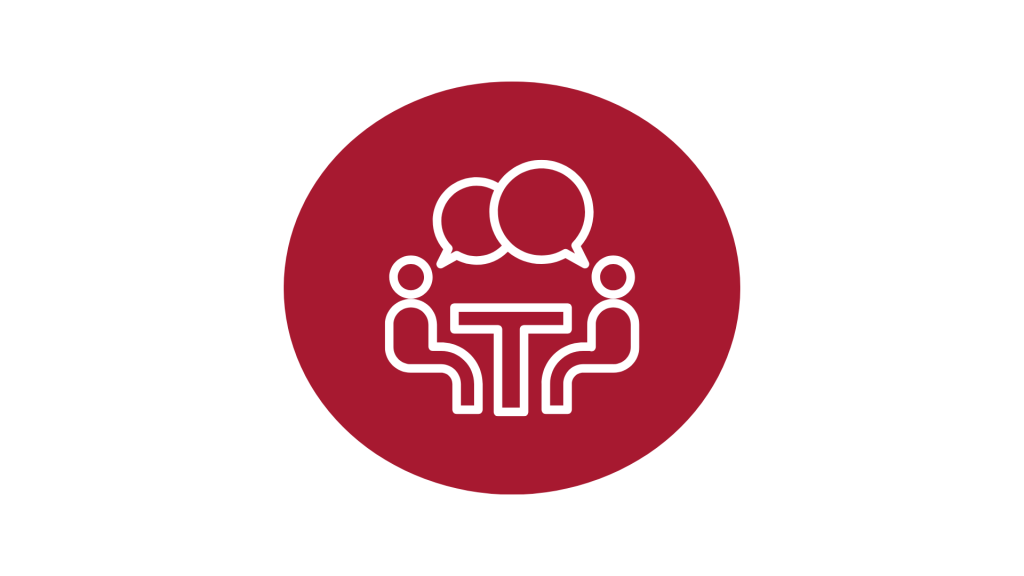 A red circle with a picture of two people sitting around a table having a conversation.