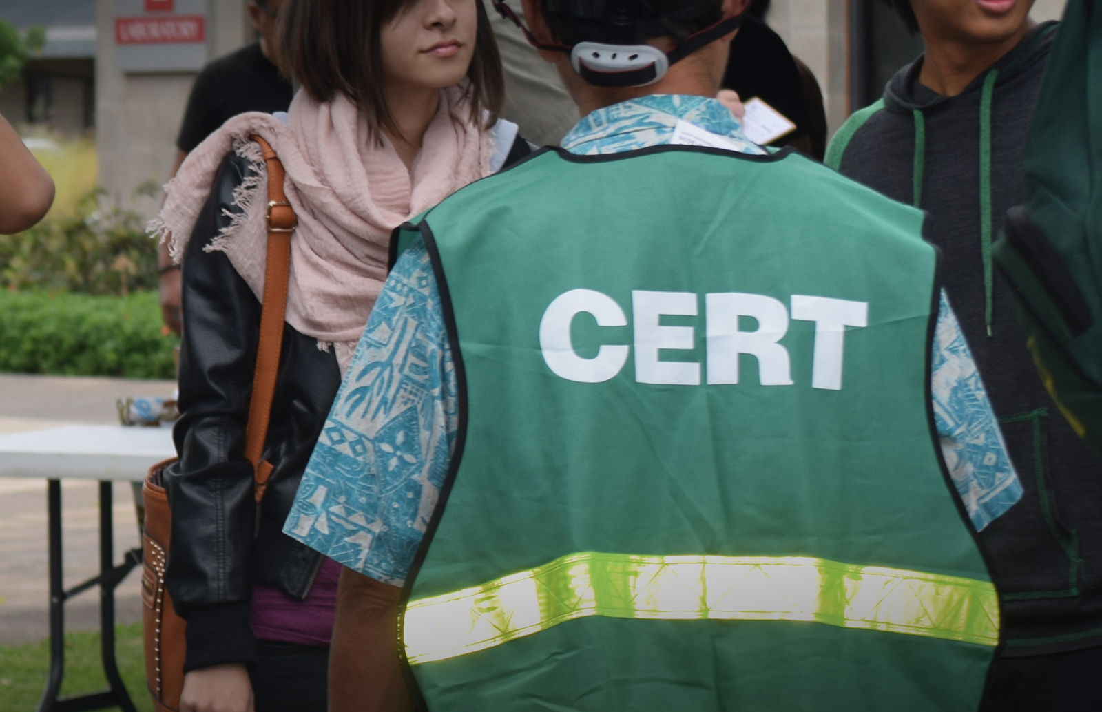 The back of student wearing a Community Emergency Response Team (CERT) green vest.