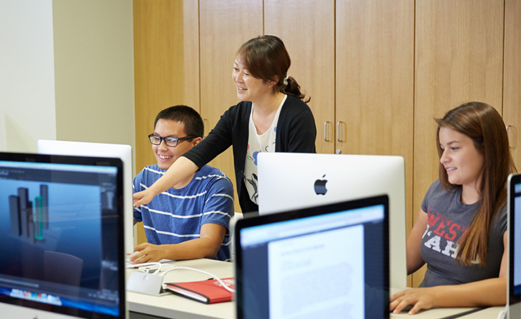 Creative media professor showing a student things on a computer.