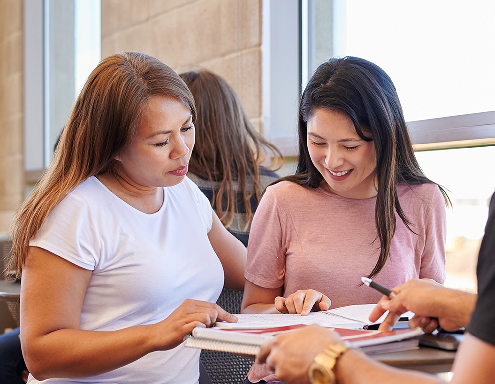 Two students studying together at a table.