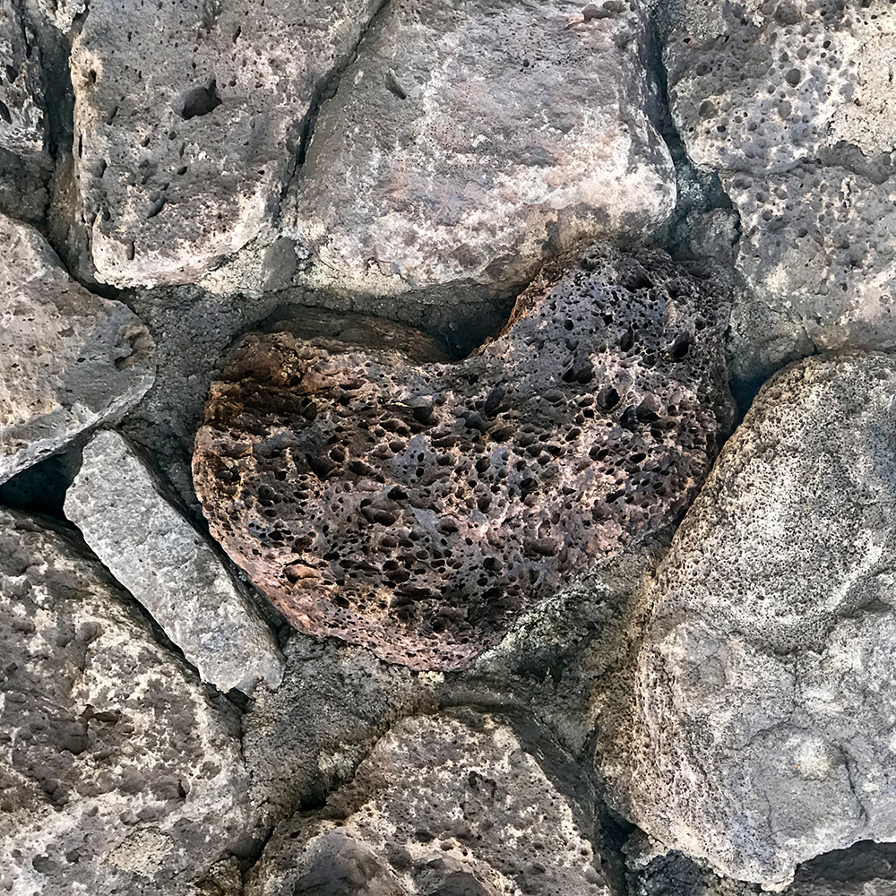 A Close-up Of A Rock Wall With The Rock In The Center Shaped Like A Heart.