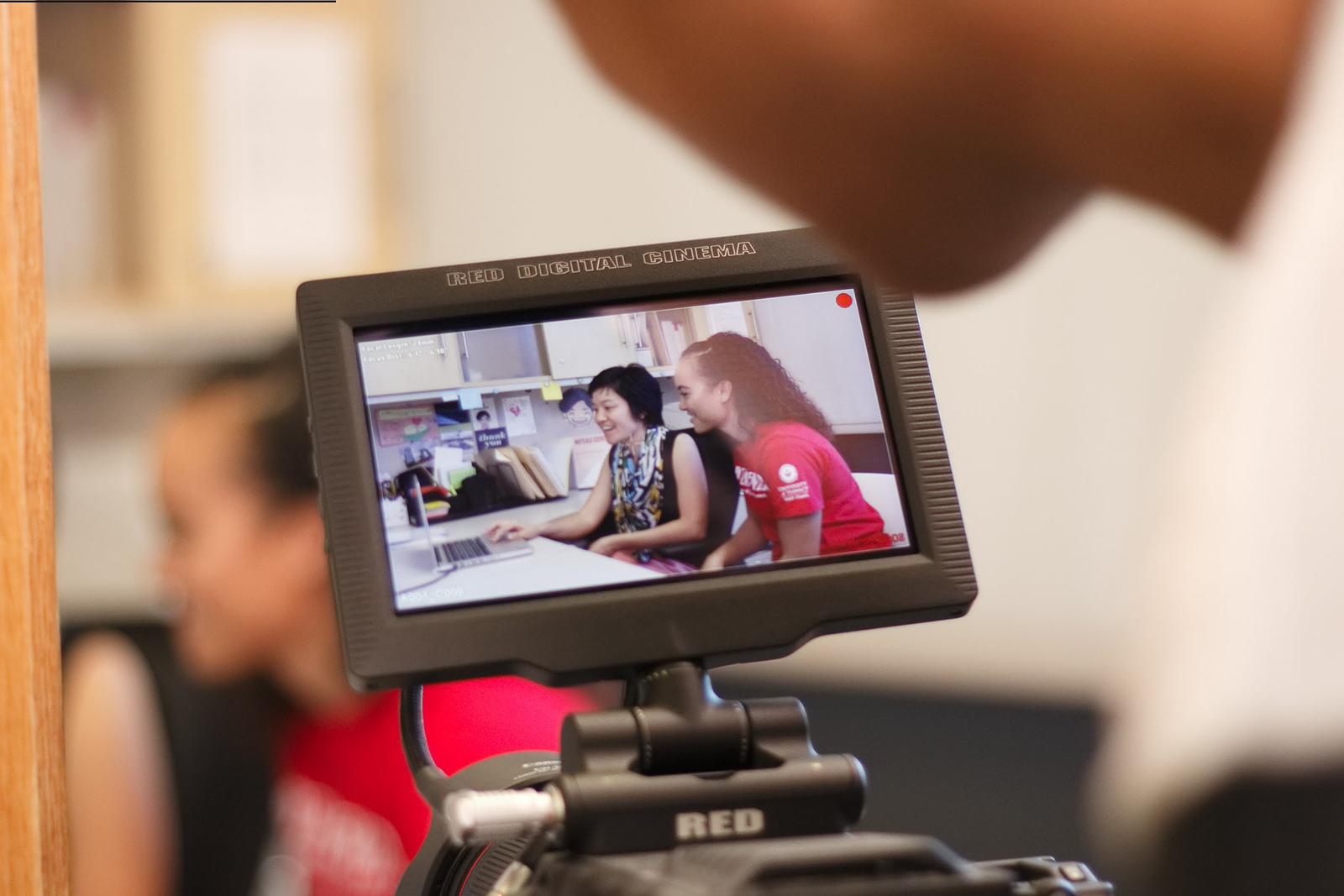 A student and a tutor seen through a camera viewfinder.