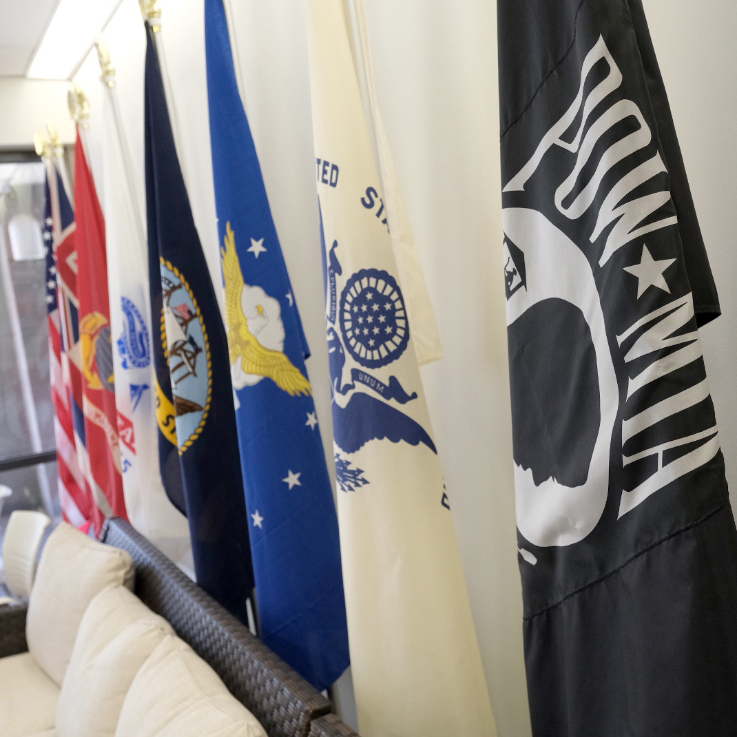 US and other military flags inside the Veterans Center of Excellence.