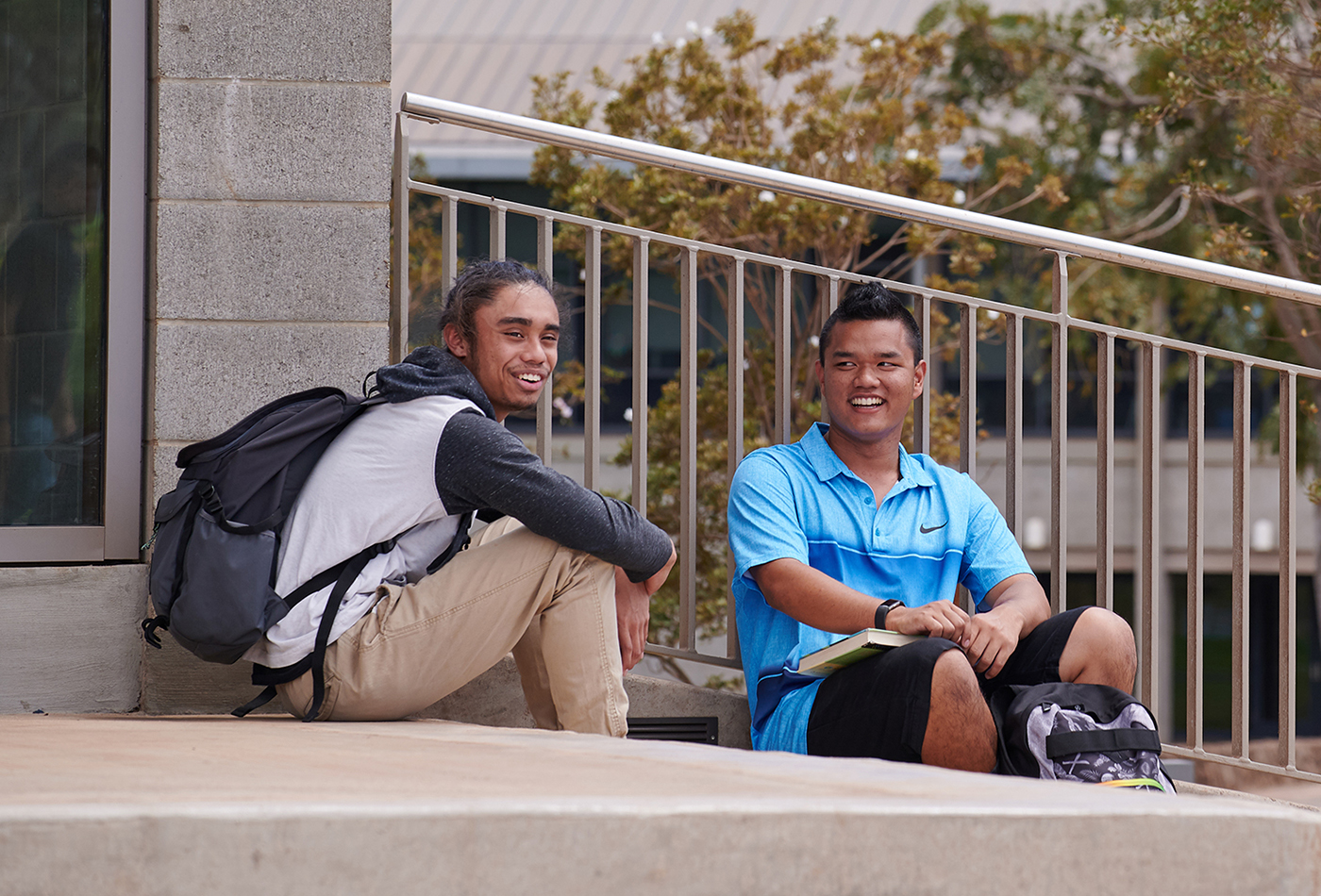 Two students sitting on the steps in front of the Administration building.