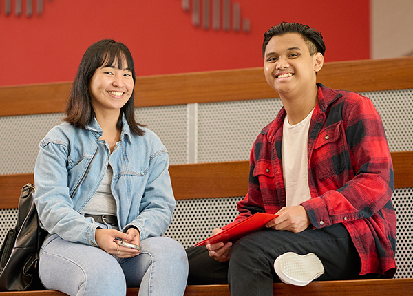 Two students sitting in the ACM building lobby.