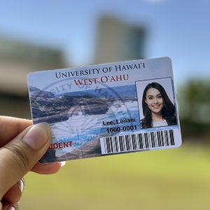 A close up of a UHWO student ID being held outside.